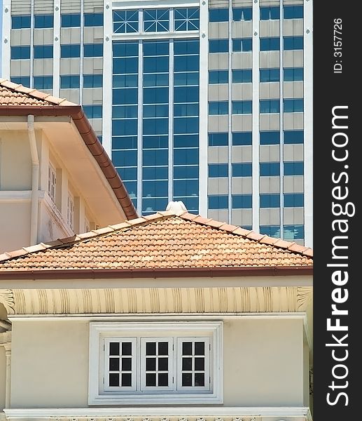 Detail of traditional style building in the foreground with modern, high-rise office building in the background. Detail of traditional style building in the foreground with modern, high-rise office building in the background