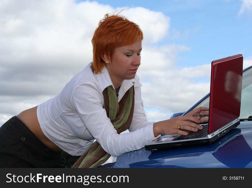 Young woman with red notebook on cowl of blue car. Young woman with red notebook on cowl of blue car