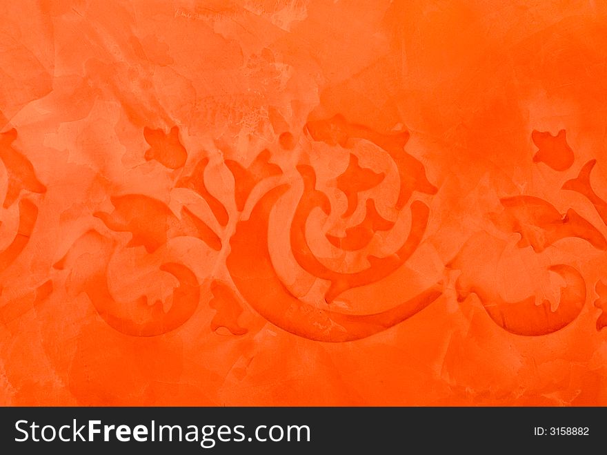 Old ancient ornamental painting detail in orange on a special primed wall as background a little blur as the origin