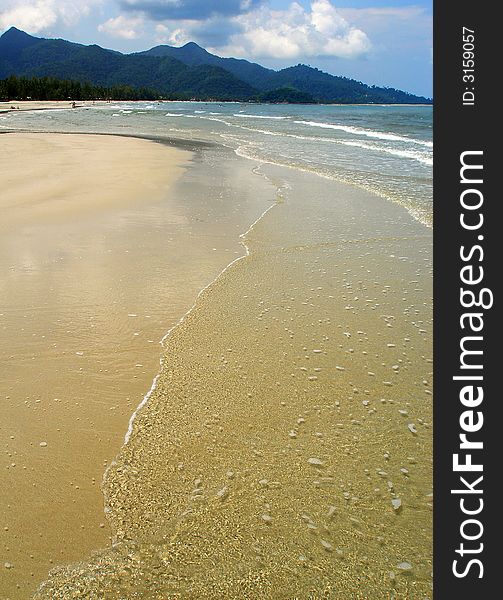 Sandy clear beach and calm sea. Far away rain forest. Sandy clear beach and calm sea. Far away rain forest.