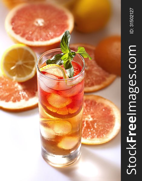 Fresh and cold ice tea with sliced grapefruit, lemon and mint