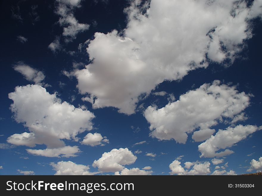Fluffy clouds fill the blue sky above Namibia. Fluffy clouds fill the blue sky above Namibia
