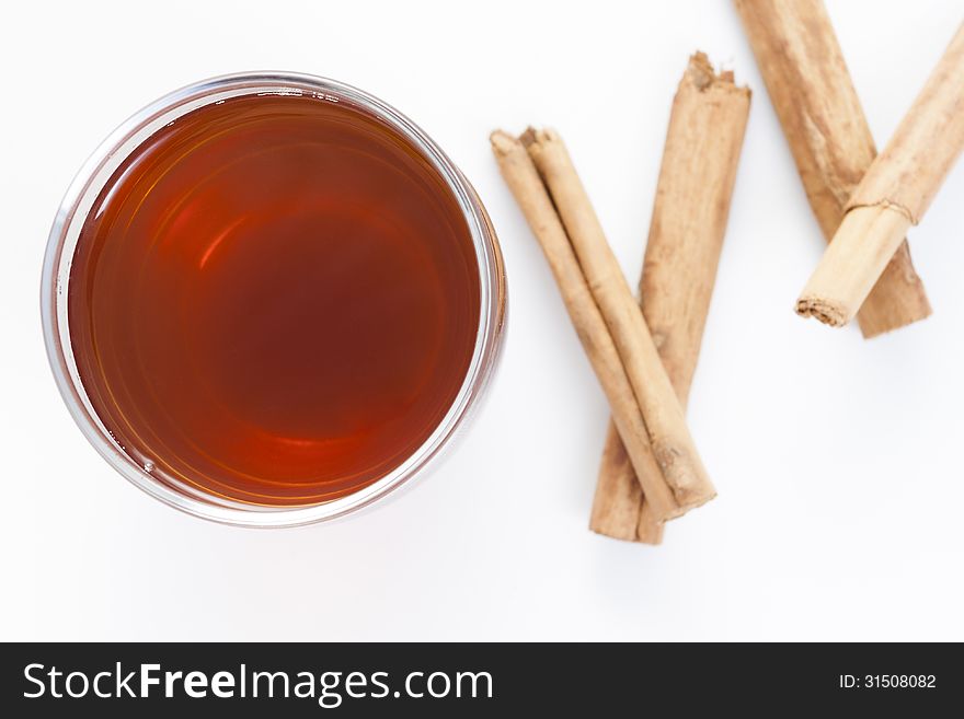 Cup of red tea with cinnamon isolated on white background.