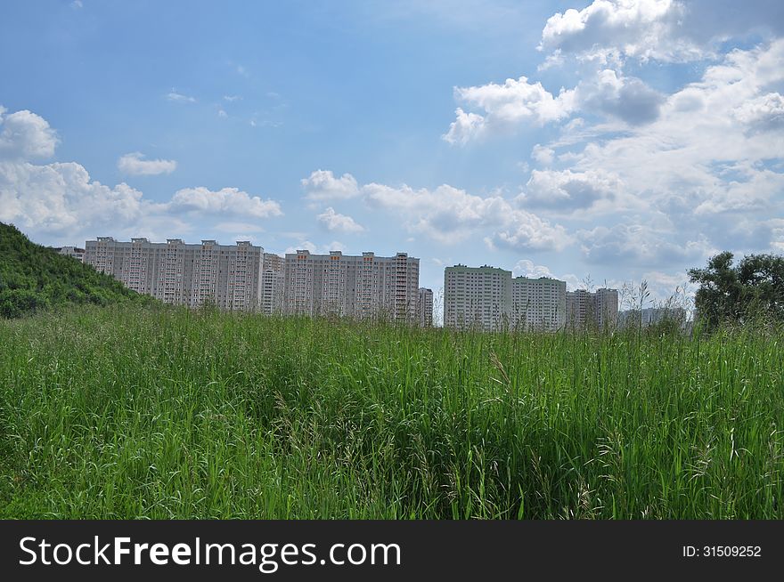 New buildings on the outskirts of Moscow. The building is hardly possible to find among the weeds.