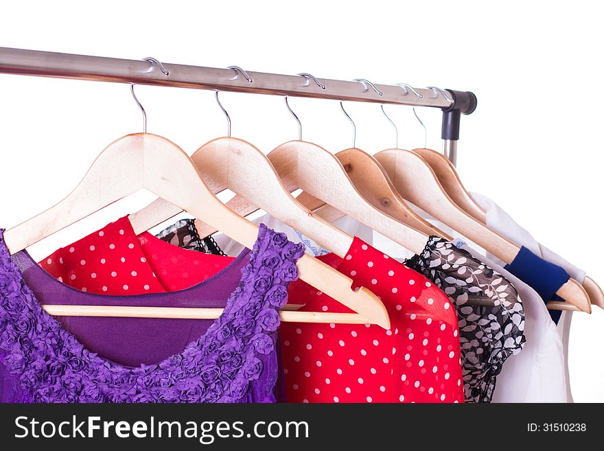 Dresses of different colors on wooden hangers