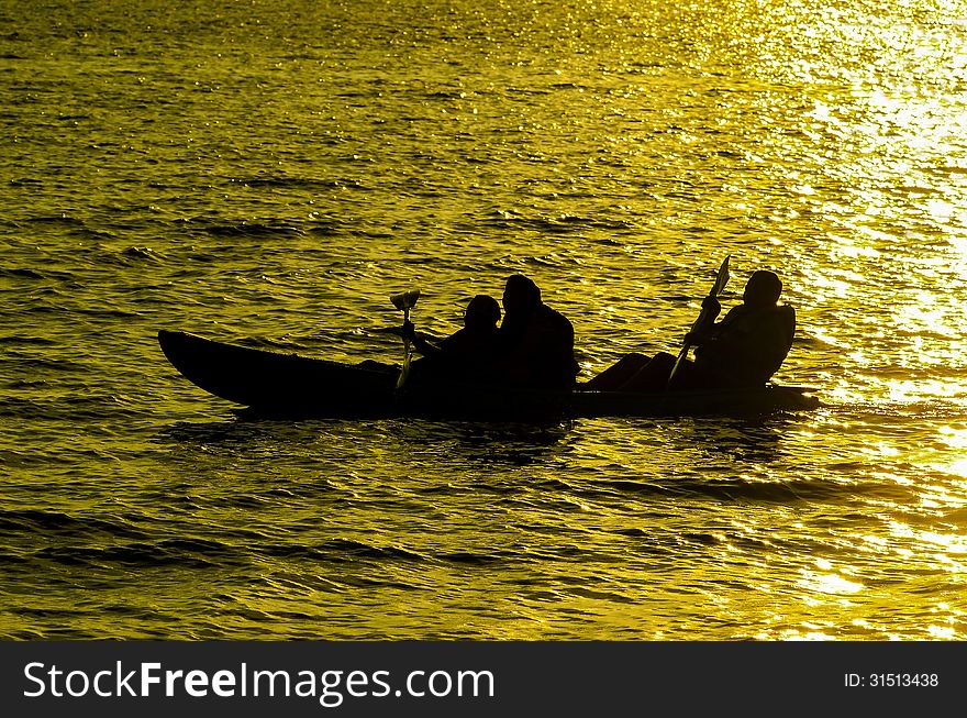 Silhouette of Three person kayaking in the sea at sunset in Koh Chang Thailand