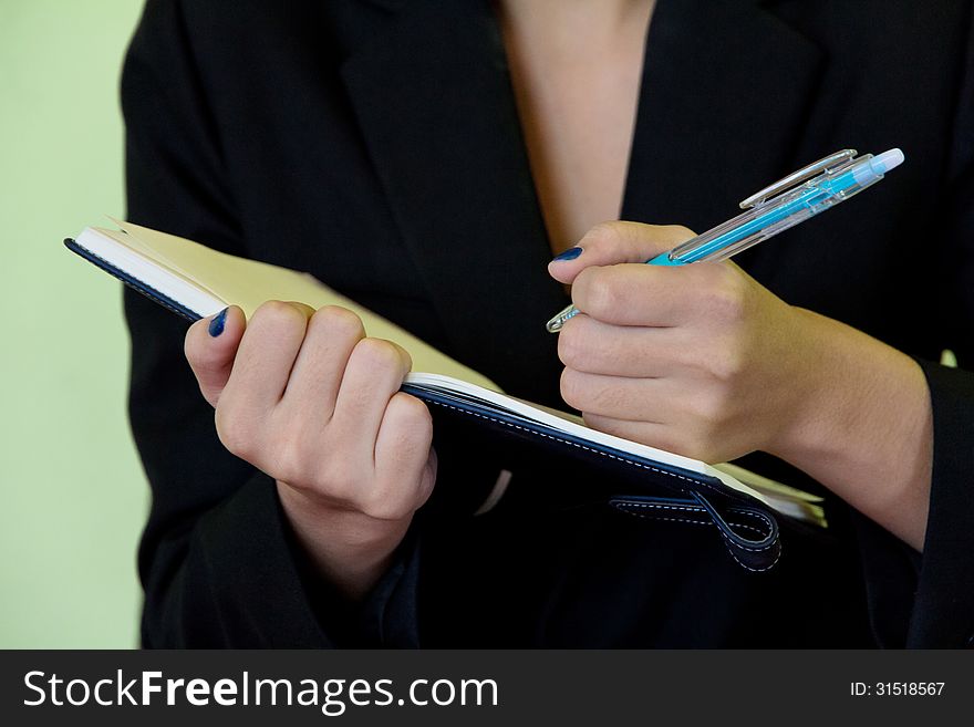 Businesswoman writing in notebook