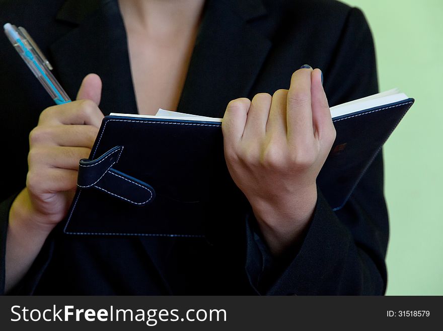 Close up image of Businesswoman writing in notebook