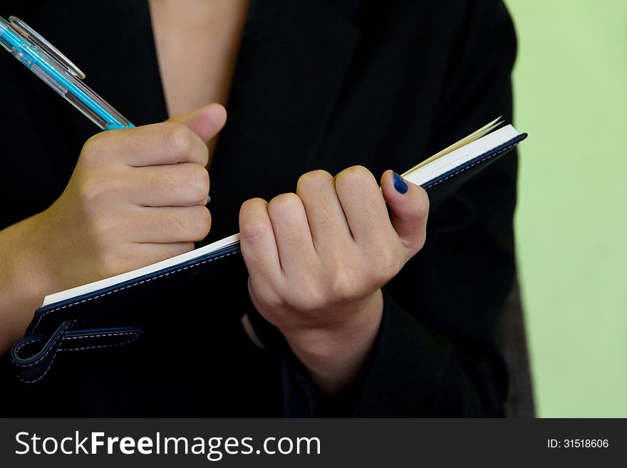 Image of Businesswoman writing in notebook