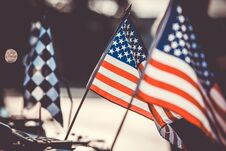 Small American Flags And Checkered Flag Flying Against Evening Light Royalty Free Stock Photography