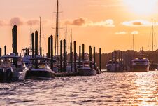 Group Of Boats Docked At Busy Harbor At Sunset Stock Photos