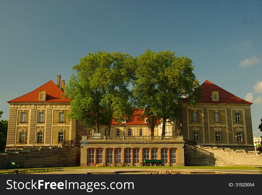 The photograph shows the ducal palace in Zagan, located in western Poland. View from the South. In the foreground, at the base of the building is a conservatory. The photograph shows the ducal palace in Zagan, located in western Poland. View from the South. In the foreground, at the base of the building is a conservatory.