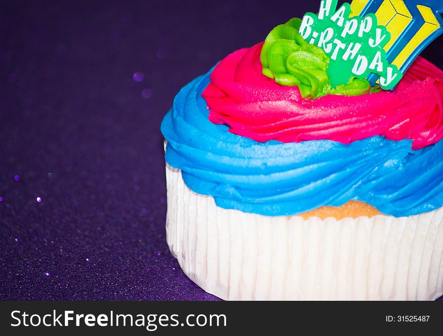 Colorful cupcake on a purple background