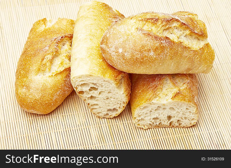 Fresh Crusty the cut baguettes on a wooden background.