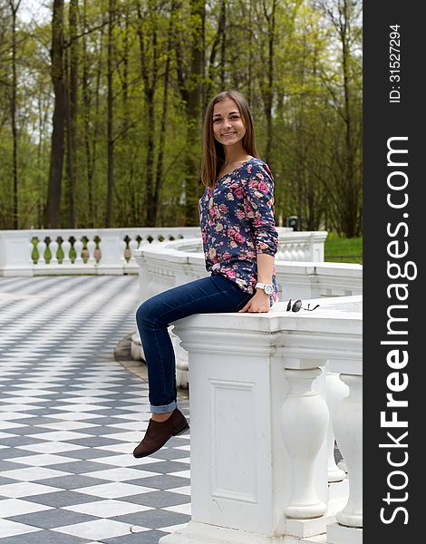 Girl sitting on the railing in the park. Girl sitting on the railing in the park