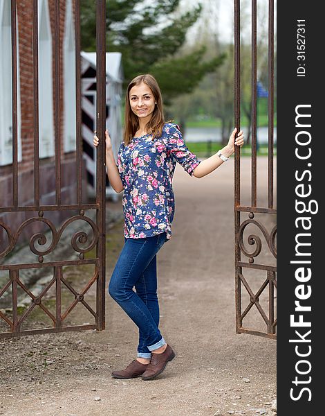 Full-length portrait of a beautiful girl with a fence