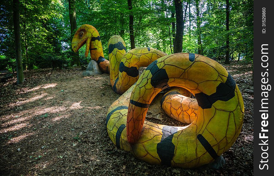A 15 meter long, yellow and black concrete snake in de woods, for kids to play on. A 15 meter long, yellow and black concrete snake in de woods, for kids to play on.