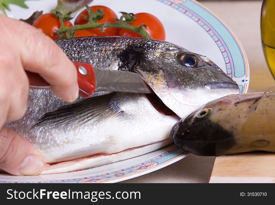 Preaparing a plate of fish with a sea bream