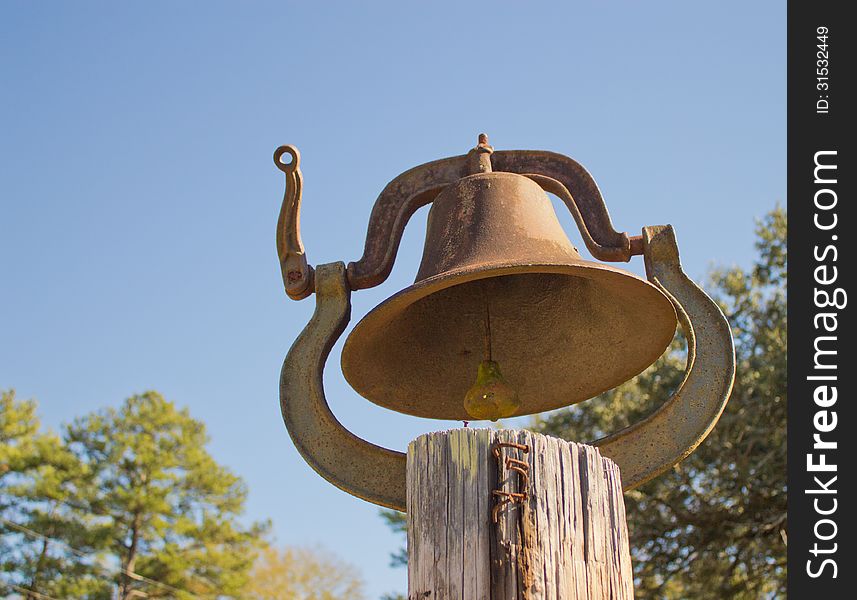 Dinner bell on wooden post