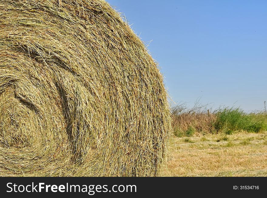 Closeup on straw bale under blue sky