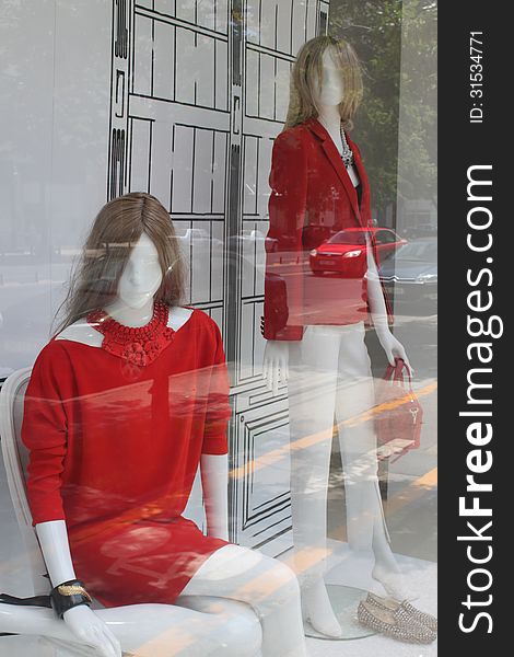 Red clothing for women in shopwindow with street cars reflection