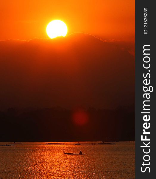 Fishing by boat across the lake as the sun began to sink in Boyolali, Central Java, Indonesia. Fishing by boat across the lake as the sun began to sink in Boyolali, Central Java, Indonesia
