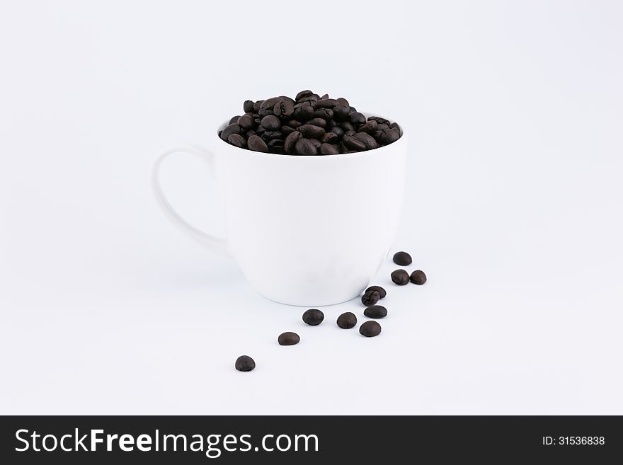 Cofee beans in the cup on white background