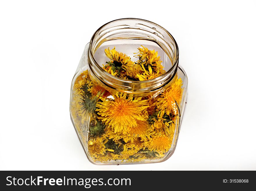 Dandelion jam in a glass jar on a white background