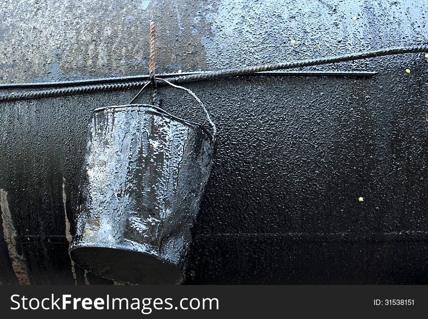 Crumpled, dirty metal bucket, which poured oil