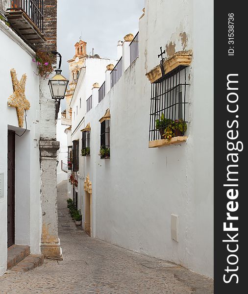 The narrow street with old houses, Arcos de la Frontera, Andalusia, Spain.