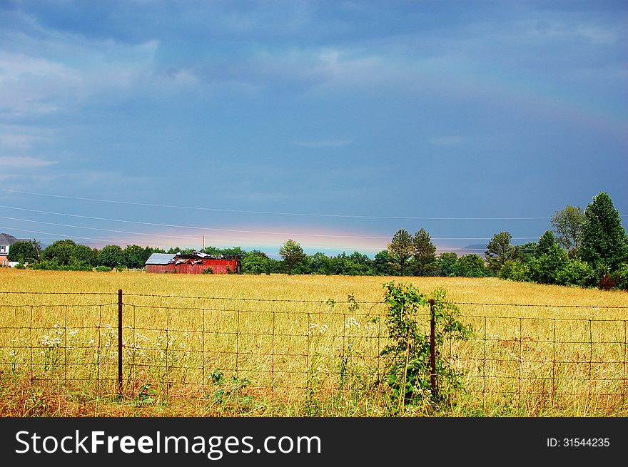 Double Rainbow rising over barn in field. Double Rainbow rising over barn in field