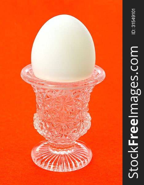 An egg in a cup on a red background. An egg in a cup on a red background.