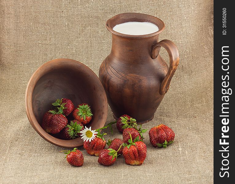 Rustic still life of strawberries in the clay pot