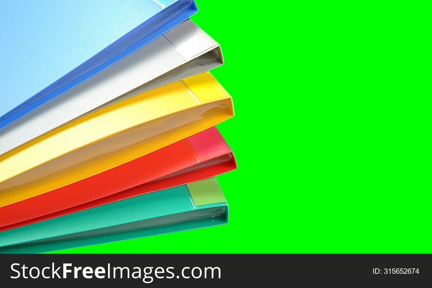 Stack of colorful folders on a green background