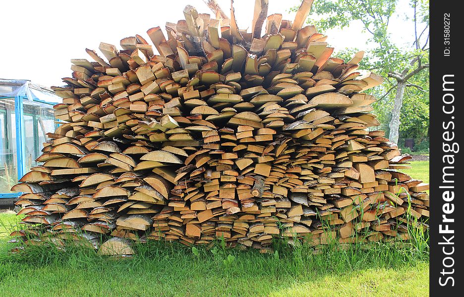 Various wood firewood stacked in a pile. Various wood firewood stacked in a pile