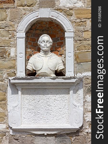 Ancient bust in a niche on a church wall