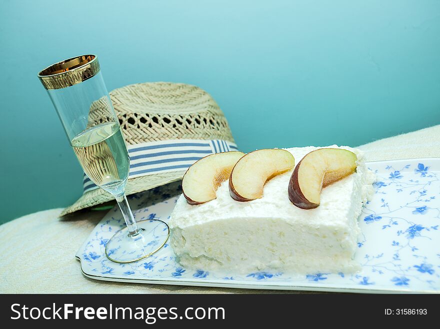 Apple pie with whipped cream, sweet white wine and a man's hat