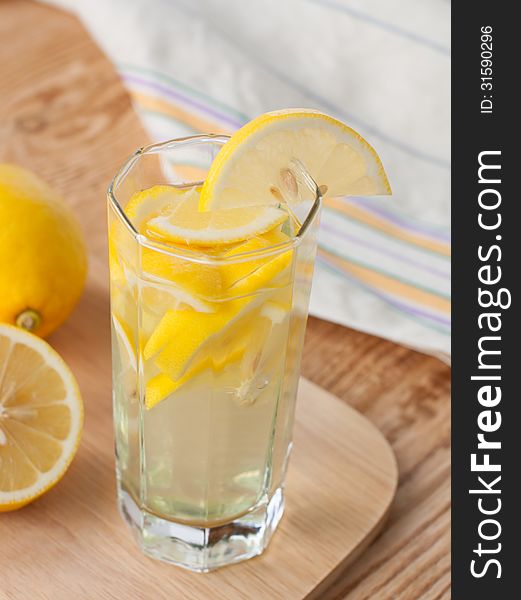 Lemon drink in a glass and lemons. Lemon drink in a glass and lemons