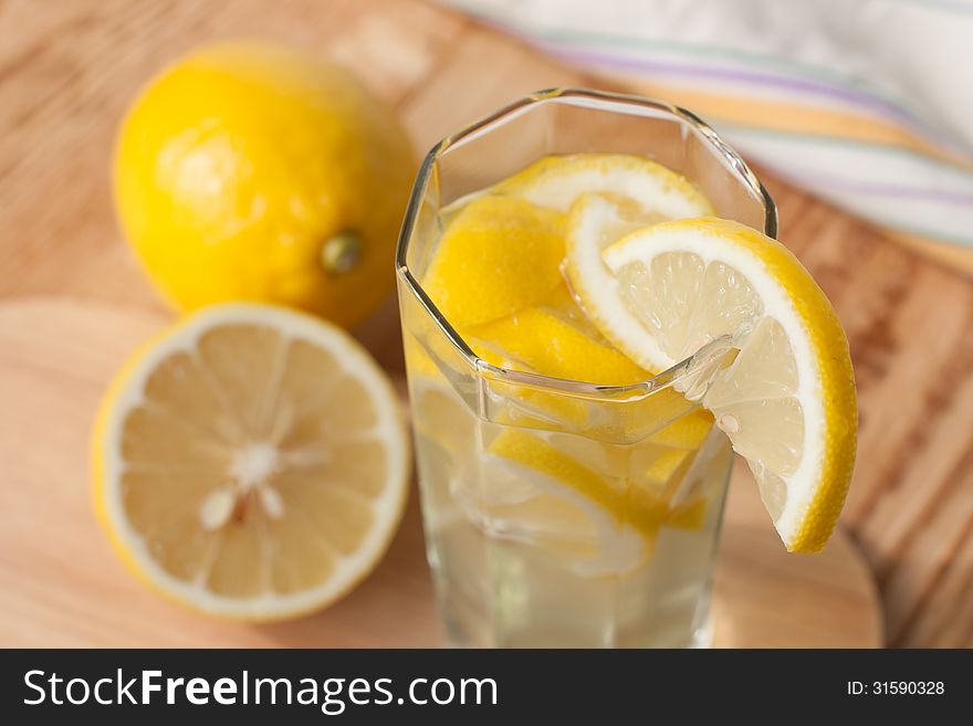 Homemade lemonade in a glass on a wooden surface. Homemade lemonade in a glass on a wooden surface