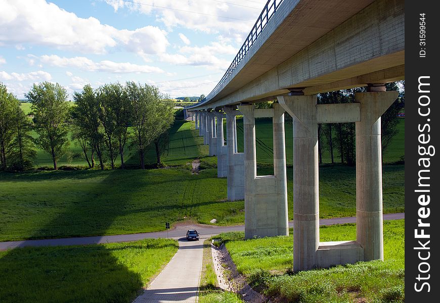 Modern bridge with green fields and blue sky