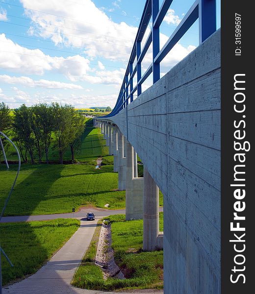 Modern bridge with green fields and blue sky