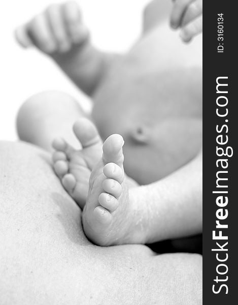 10 day old baby, in his mothers lap, showing his little feet to the camera. 10 day old baby, in his mothers lap, showing his little feet to the camera.