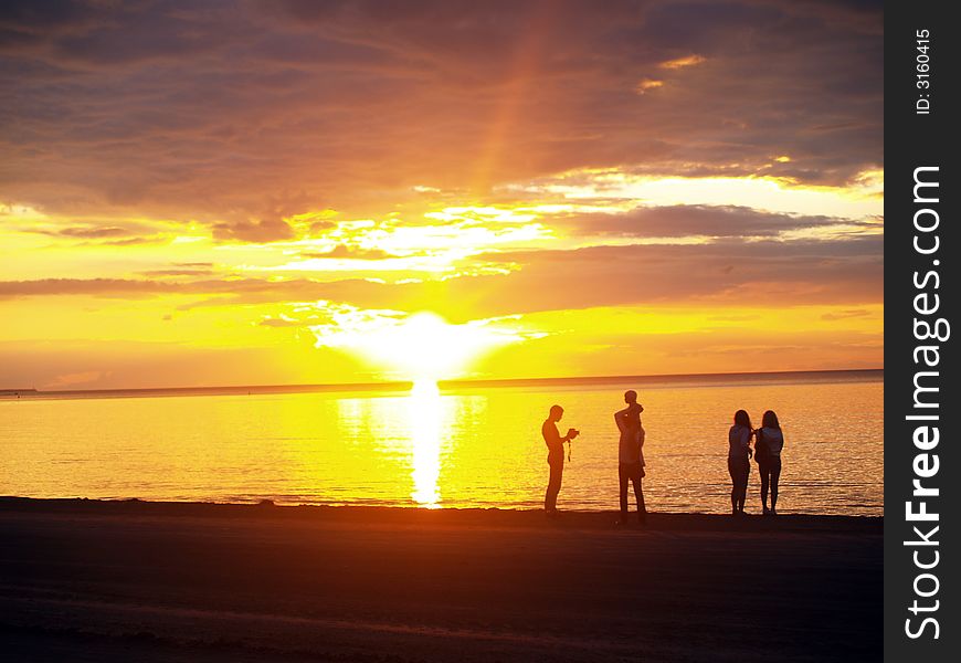 Family looking sunset in the sea