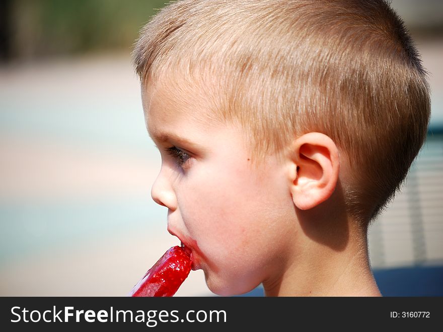 Little boy eating a popsicle. Little boy eating a popsicle