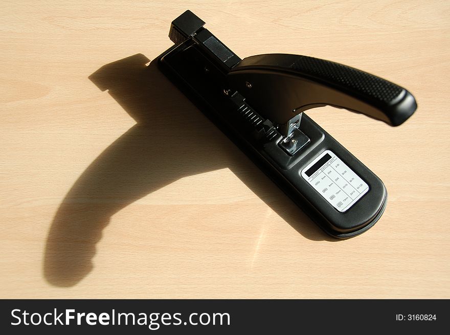 Big stapler with a big shade on the desk. Big stapler with a big shade on the desk.