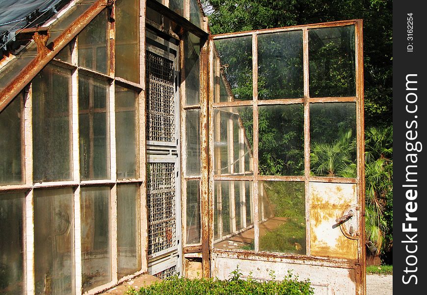 This is the old and rusty greenhouse in green park. I love it because of his dirty and large windows. This is the old and rusty greenhouse in green park. I love it because of his dirty and large windows.