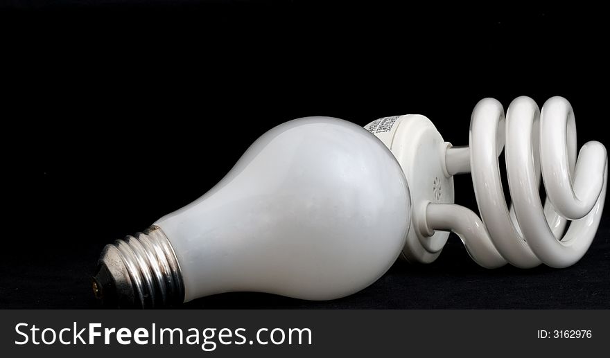 Compact fluorescent and incandescent light bulbs on black background. Compact fluorescent and incandescent light bulbs on black background