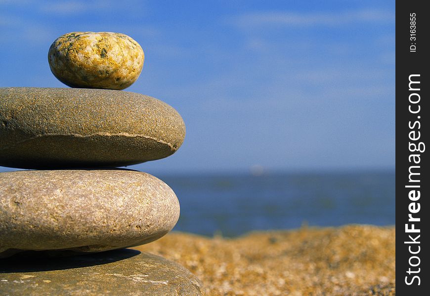 Stones on the beach on blue sky background. Stones on the beach on blue sky background