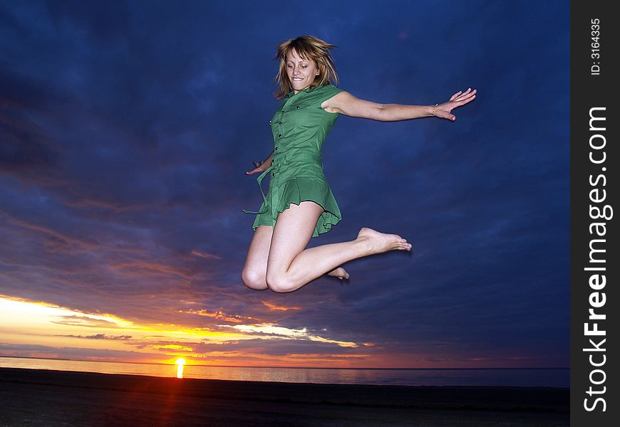 Beautifully girl jumping in sunset