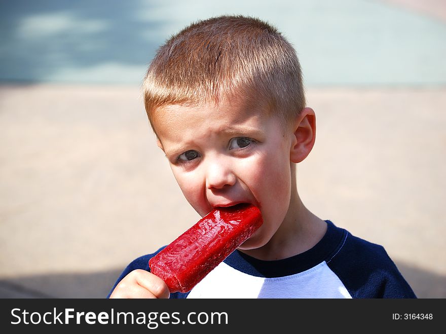 Little boy eating a popsicle. Little boy eating a popsicle